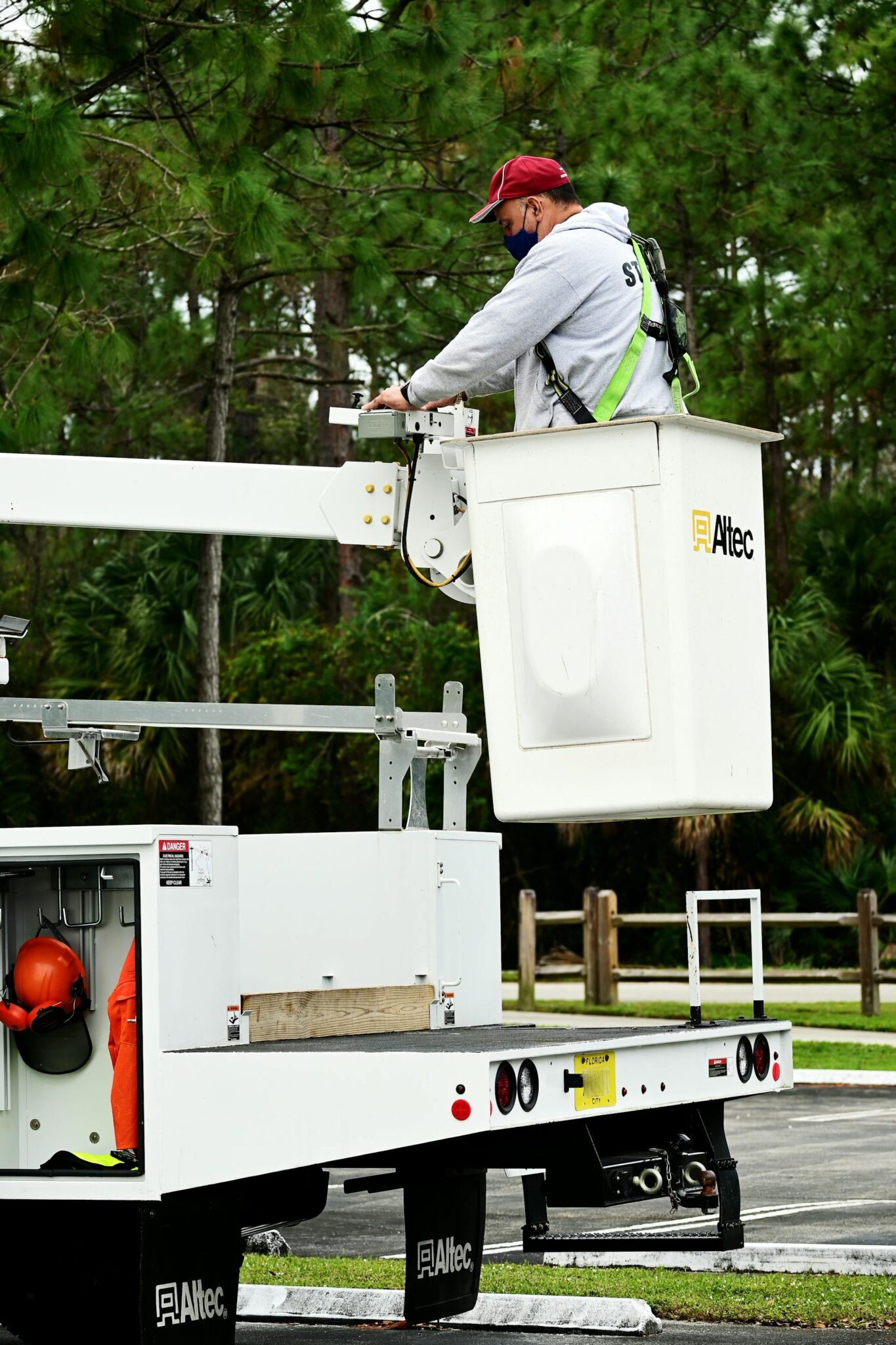 Statybininkas tikrina saugos diržus ir kritimo apsaugos įrangą statybų aikštelėje.
